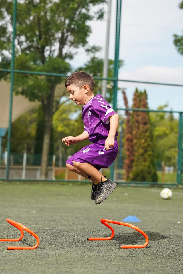 Futbol antrenmanında engelin üzerinden atlayan genç sporcu