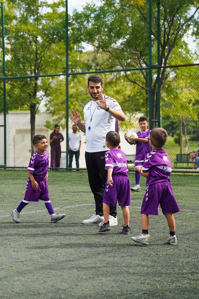 Antrenörleriyle açık sahada çalışan genç futbolcular