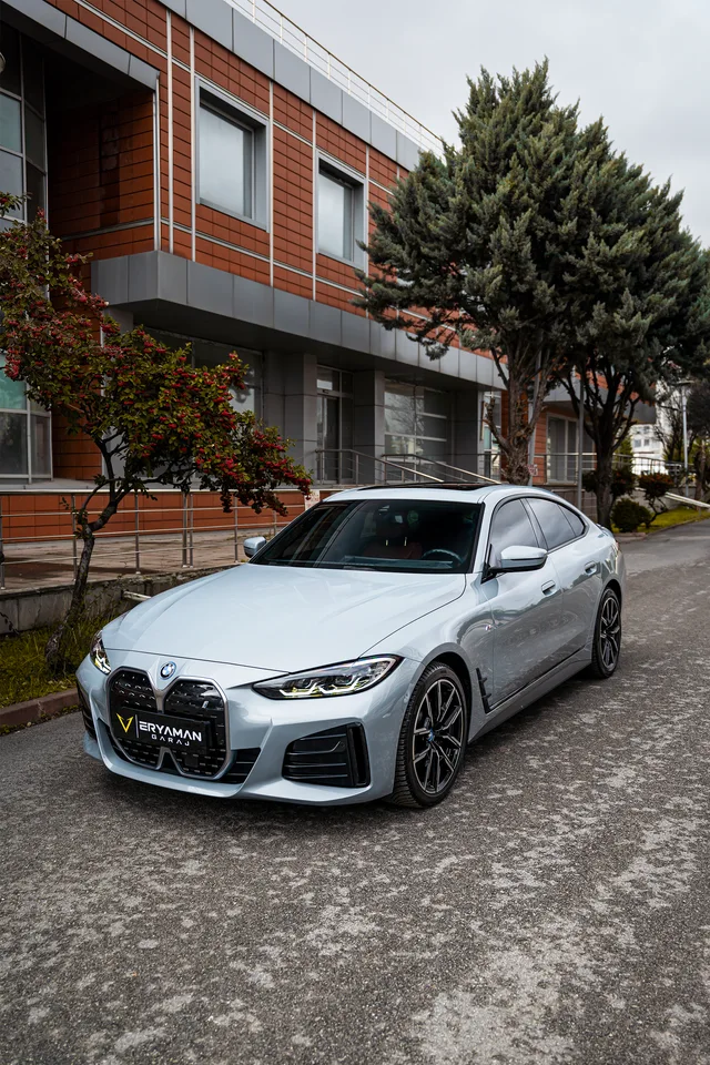 Modern bir binanın önünde beyaz BMW