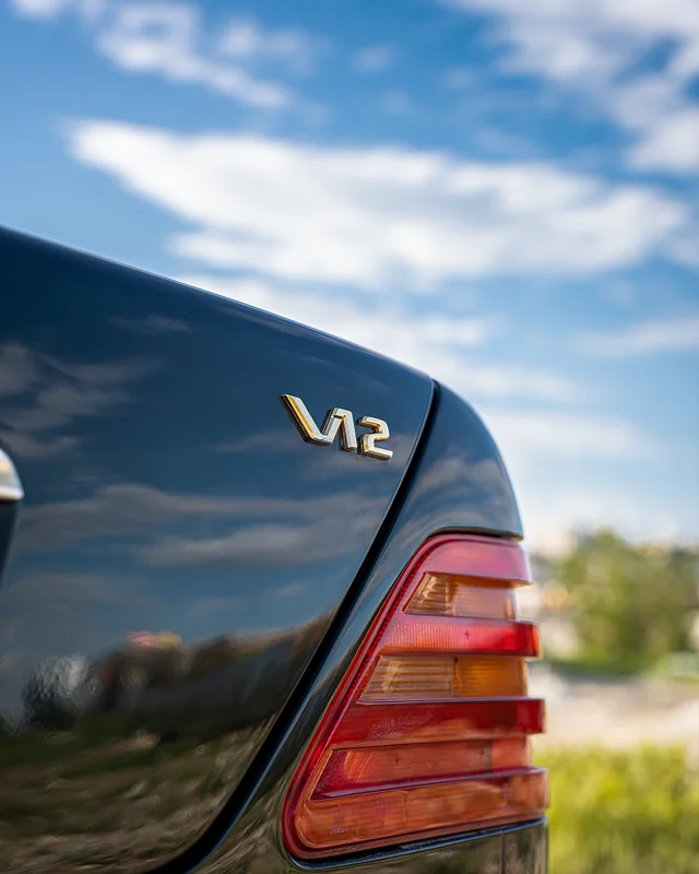 Mavi Mercedes’in V12 amblemi ve arka far detayı